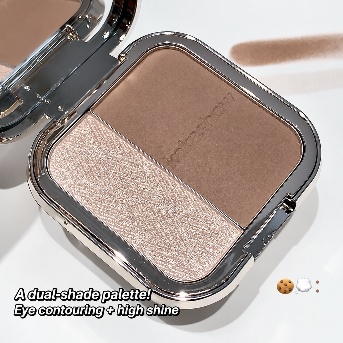 An open makeup compact showing a dual-shade face contouring and highlighter palette. One pan is a matte medium brown and the other is a shimmering champagne-beige.